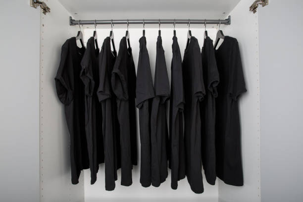 Стопка черной одежды на полке в гардеробе с украшениями